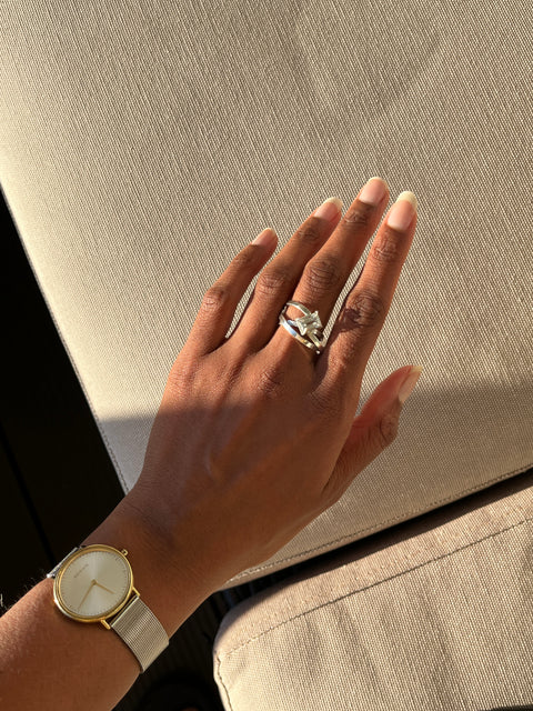 hand wearing a silver ring with a zirconia
gemstone