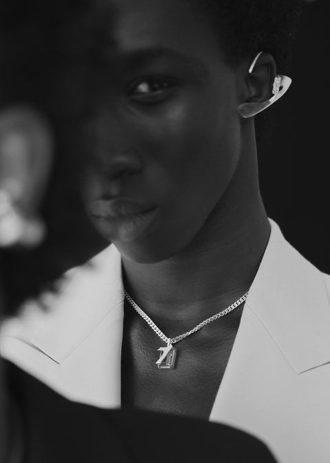 Man wearing a silver necklace with gemstone